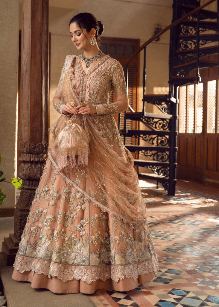 Luxury Pakistani bride wearing a gold embellished lehenga with traditional jewelry.