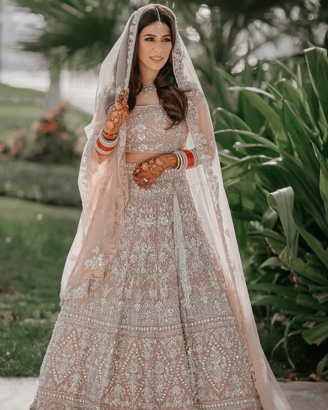 Pakistani bride wearing a pastel luxury lehenga for a 2025 wedding.