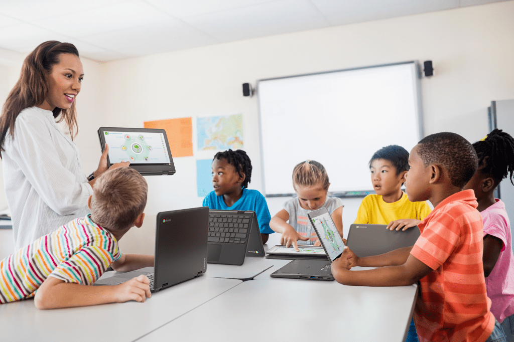 Teacher guiding students using Chromebooks in Punjab classroom.